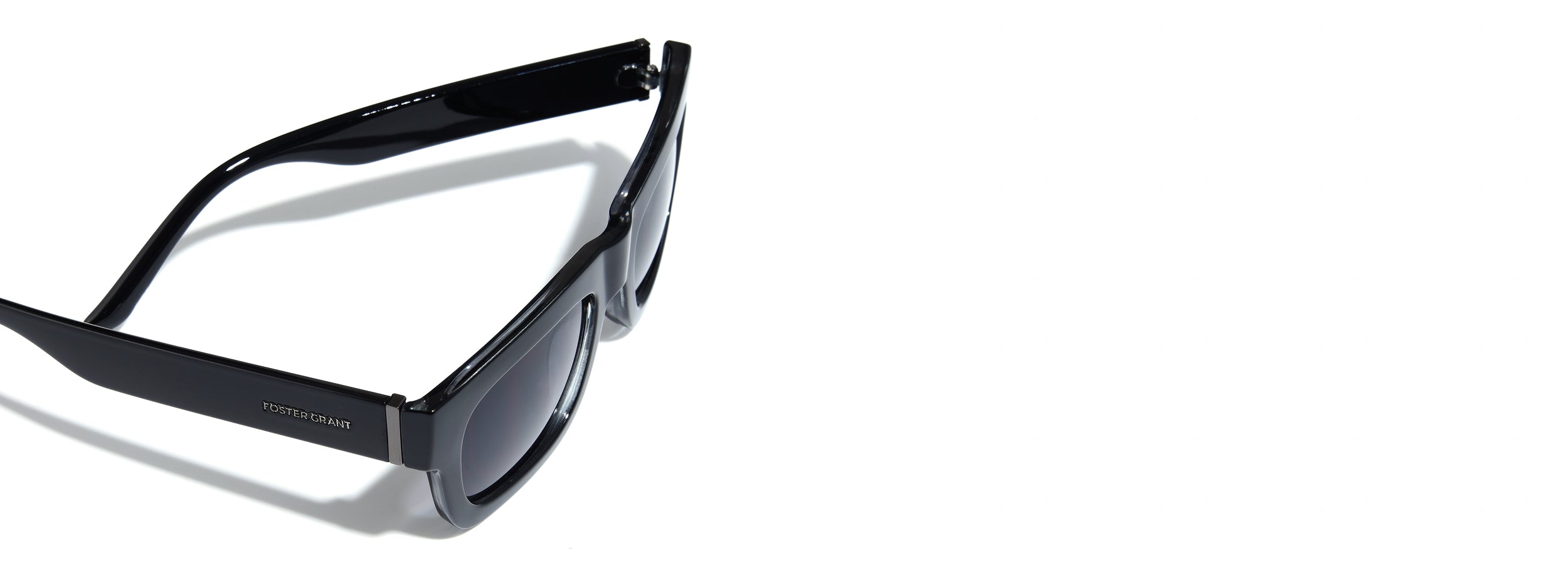Black sunglasses with a Foster Grant logo on the temple a white background